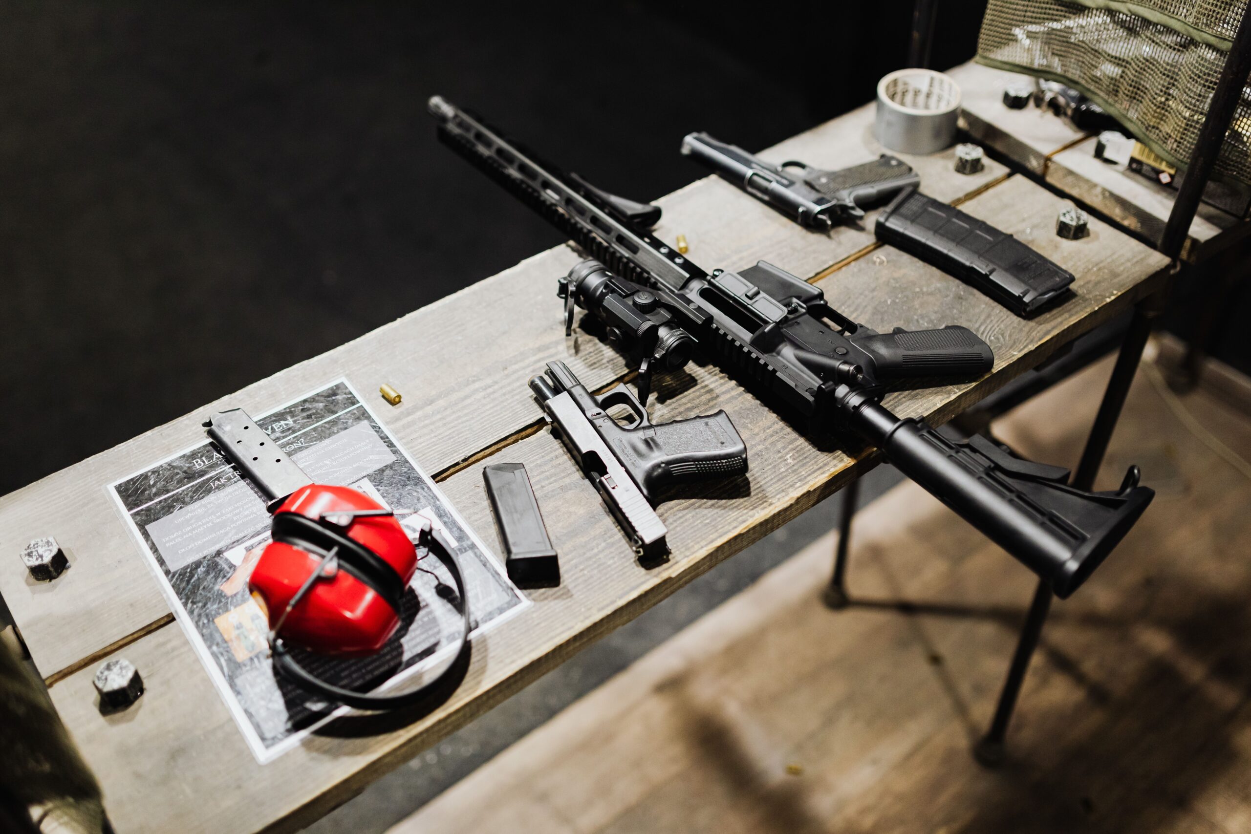 Firearms and accessories displayed on a wooden table — stock photo via Pexels